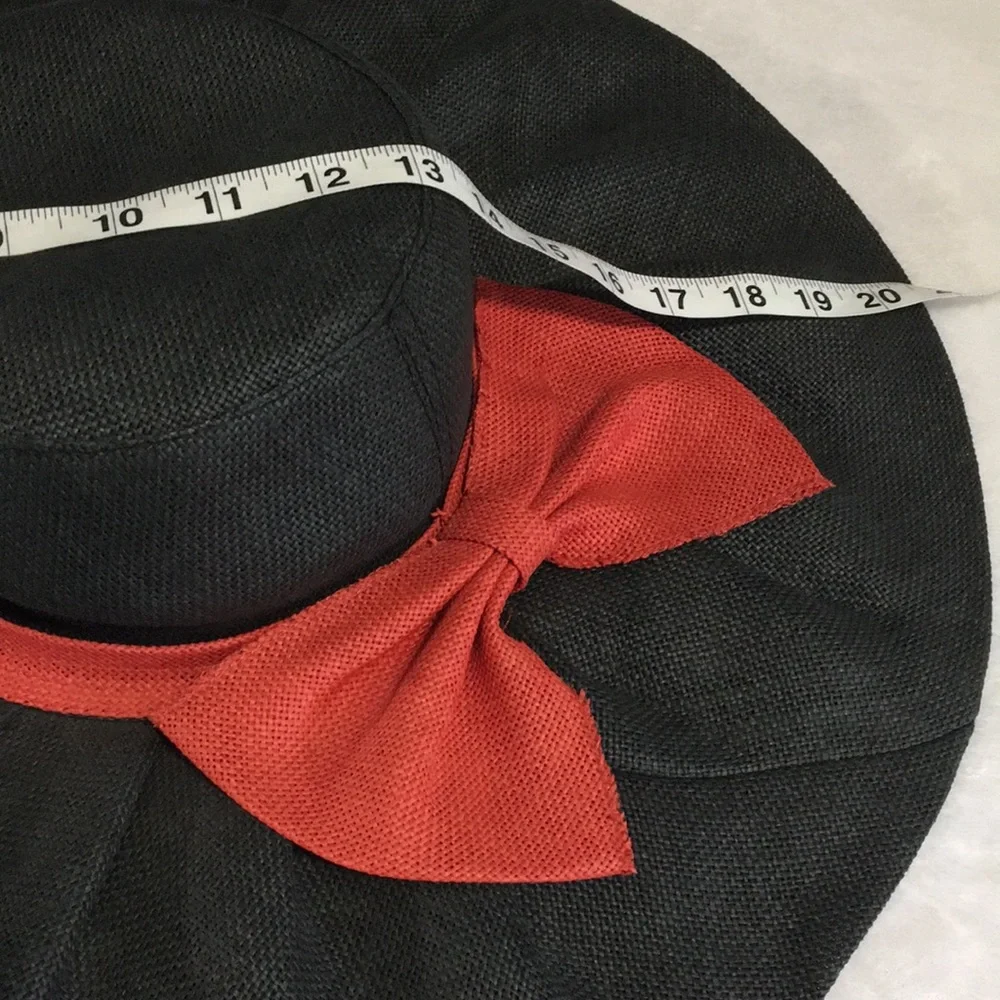 Woman’s black wide brim floppy burlap type hat with red bow.